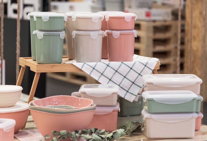 Multiple sizes of plastic food storage containers stacked on top of each each other on a counter. 