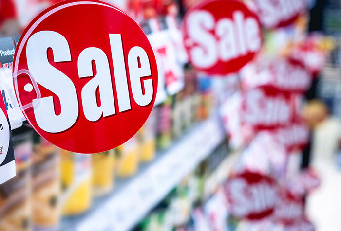 Sale signs on a grocery store shelf.