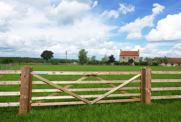 A wooden fence around the perimeter of a homestead.