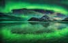 Green aurora encircling a mountain and lake