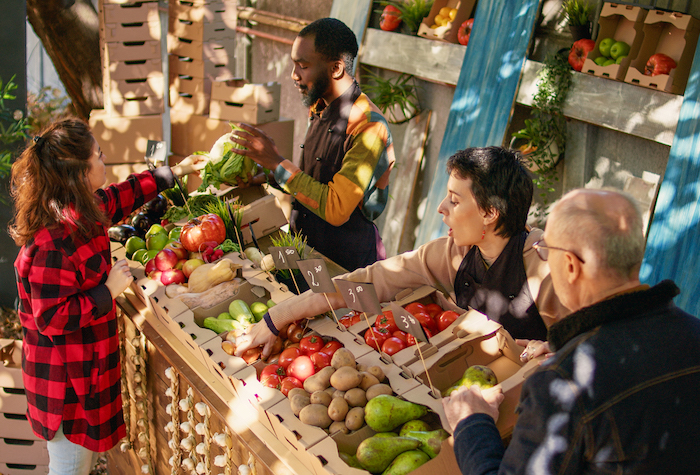 A homesteader selling homegrown produce at a farmer's market.