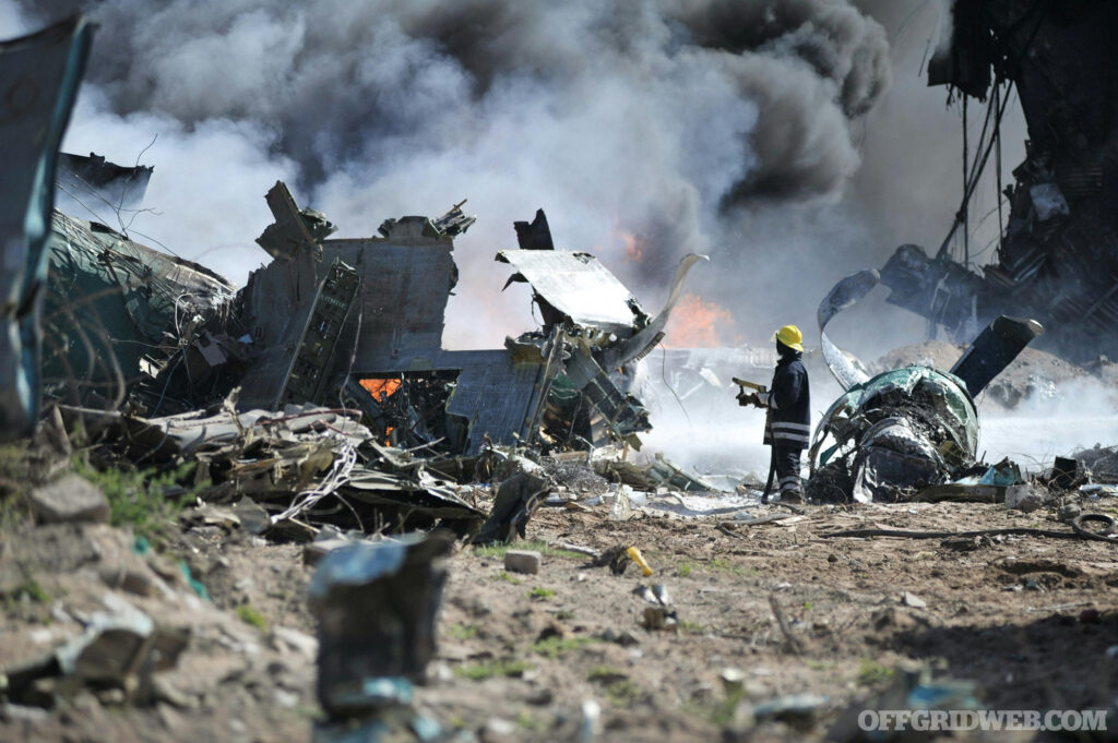 Photo of burned ruins with a firefighter trying to put out the flames.