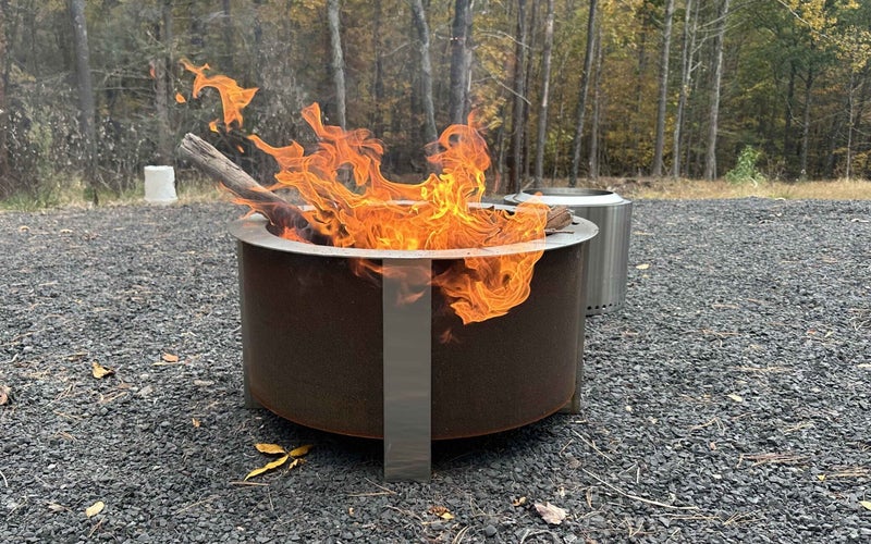 The Breeo fire pit with a fire on gravel