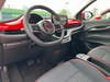 black and red interior of a fiat, showing two front seats, steering wheel, and screen